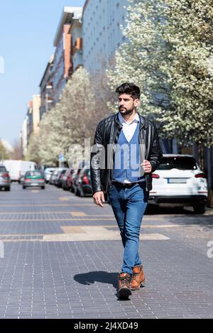 Full length of handsome man crossing the road street. City lifestyle portrait. Stock Photo