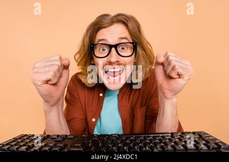 Portrait of handsome trendy cheery lucky red-haired guy playing game having fun isolated over beige pastel color background Stock Photo