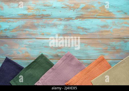 Multicolored napkins from bottom side of shabby wooden background top view with copy space Stock Photo