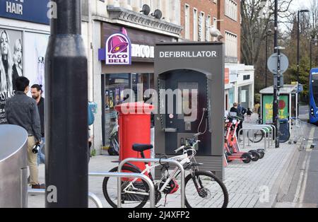 A public defibrillator unit in a booth in a busy British street in a major city in the United Kingdom Stock Photo