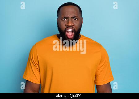 Photo of angry shocked guy wear orange t-shirt screaming you open mouth isolated blue color background Stock Photo