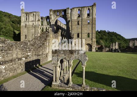 The reconstructed arcade (foreground) in the cloister with the presbytery behind showing north & south transepts of ruined Rievaulx Cistercian Abbey