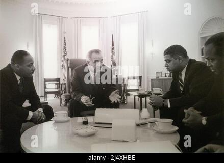 United States President Lyndon Baines Johnson LBJ speaking black civil rights leaders in the Oval Office taken on January 18, 1964 by Yoichi Okamoto, President Lyndon B. Johnson meets with a group of civil rights leaders. Among the group are the Rev. Dr. Martin Luther King, Jr. of the Southern Christian Leadership Conference (left), Whitney M. Young, Jr. of the National Urban League (right), and James Farmer of the Congress of Racial Equality (far right). Stock Photo