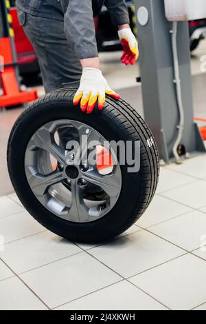 Auto mechanic balances the car wheel Stock Photo