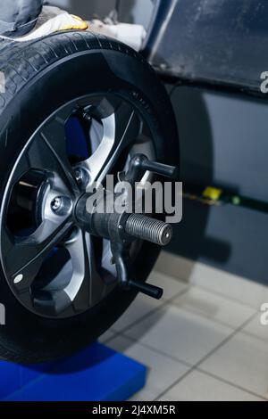 Auto mechanic balances the car wheel on the wheel balancer Stock Photo