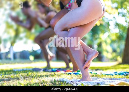 group of women practicing yoga in the park Stock Photo