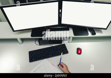 top view workspace with two blank screen monitors, keyboard and computer mouse on a desk inside software programming office, business concept, copy sp Stock Photo
