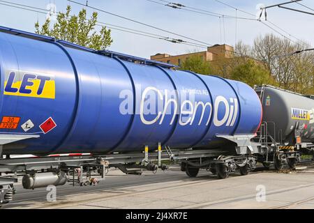 Basel, Switzerland - April 2022: Train of oil tankers crossing a road in the city's port on the Rhine River Stock Photo