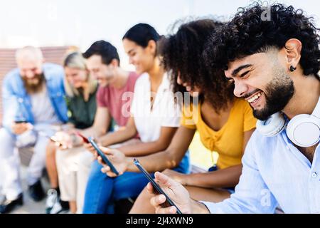 Group of young people using mobile phone in city street Stock Photo