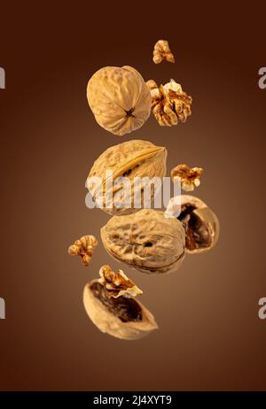 walnuts fly on brown background, selective focus Stock Photo