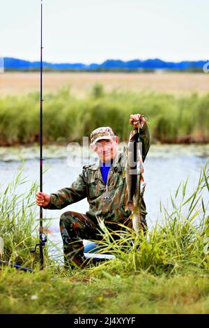 elderly man intent on fishing with a fishing rod in a