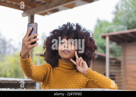 Young afro woman taking a selfie to share on her social networks. Stock Photo