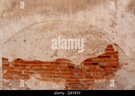 Wall texture with ancient plaster and peeling background with exposed red brick. Crack that highlights the old walled arch. Ideal for background with Stock Photo