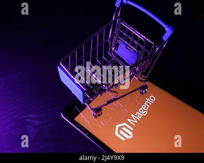 KYIV, UKRAINE - March 30, 2022. Magento ecommerce platform logo and shopping cart. Stock Photo