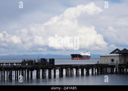 Alaskan Navigator, a crude oil tanker, under a large storm cloud in Port Angeles, Washington, USA. Stock Photo