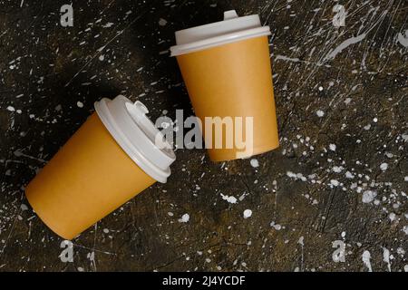 Two paper coffee disposable cups on background dirty floor Stock Photo