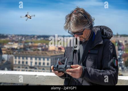 Pilot remotely controls the flight of a drone while making aerial cinematic footage Stock Photo