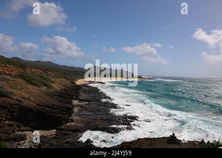 Sweeping beach scene with white waves.cliffs and blue sky Stock Photo