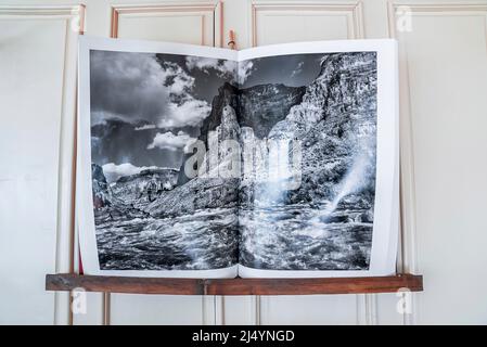 Open book with photograph of sea against mountain arranged on shelf Stock Photo