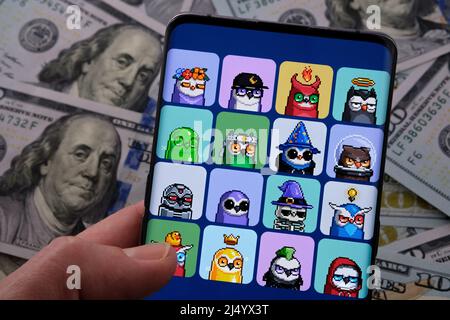 Smartphone with Moonbirds NFT  set of images hold in a hand, with blurred dollars on background. Concept. Stafford, United Kingdom, April 18, 2022. Stock Photo