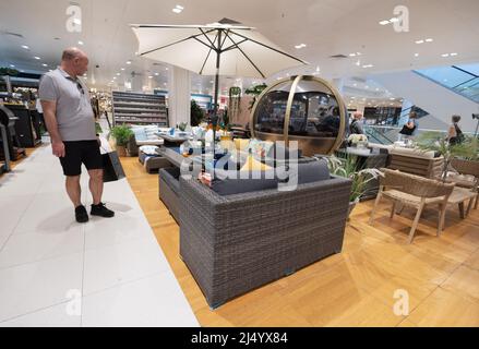 Garden furniture for sale - a man shopping for garden furniture in John Lewis store interior, Cambridge UK