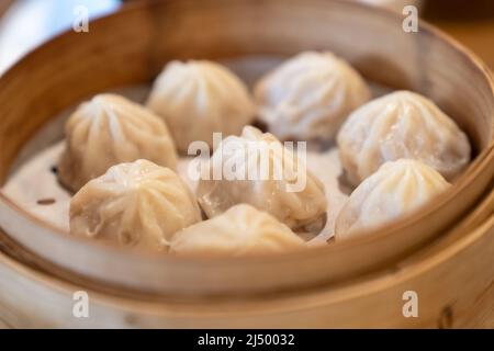 Chinese food, steamed hot Xiaolongbao in bamboo steaming basket. Stock Photo