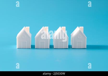 Miniature 3D printed model house on blue background Stock Photo