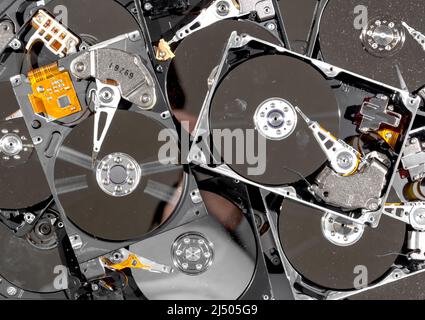 Computer hard drives being recycled. The drives have the tops removed, and are dirty and dusty. The view is from the top. Stock Photo