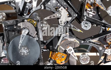 Computer hard drives being recycled. The drives have the tops removed, and are dirty and dusty. The view is from the top. Stock Photo