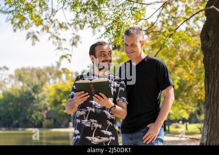 Couple of mature men reading in a lake, with a happy and relaxed attitude Stock Photo