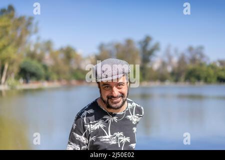 Bearded mature man wearing a beret at a lake. Copy space Stock Photo