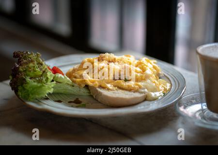 Breakfast, scrambled eggs on toast with coffee drink. Stock Photo