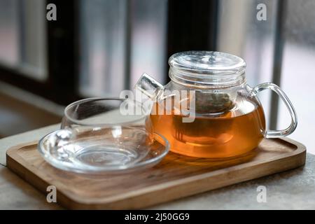Warm tea in a teapot and cup on a wooden tray. Ready to serve. Stock Photo