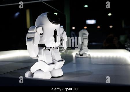 White humanoid robot at the exhibition illuminated stand with mirrors at the robot festival. Almaty, Kazakhstan - February 19, 2022 Stock Photo