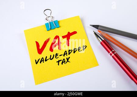 VAT. Value-added Tax. Sheet of note paper with text and a pen on a white table. Stock Photo