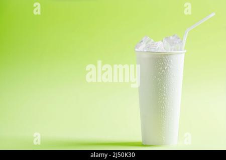 White plastic cup with ice cubes on a colored background Stock Photo