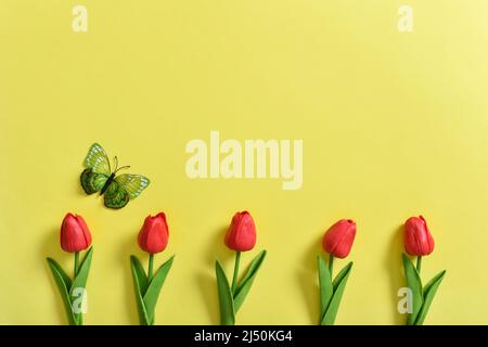 Invitation layout with tulips and a butterfly on a yellow background.  Stock Photo