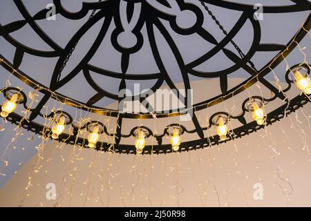 closeup chandelier with lights hanging on the ceiling. vintage outdoor decoration Stock Photo
