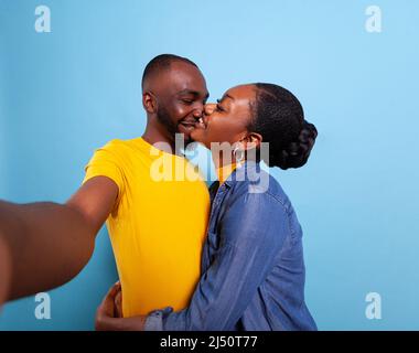 POV of happy couple holding camera and taking pictures together, expressing love and affection. Man and woman smiling and taking pictures, having fun in relationship. People embracing Stock Photo