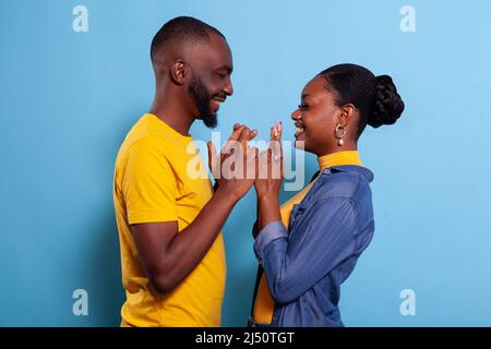 People keeping fingers crossed to wish for good luck and fortune in front of camera. Positive girlfriend and boyfriend hoping for miracle, feeling excited about future. Superstitious lovers Stock Photo