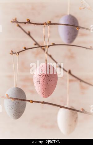 Colorful decorative easter eggs in pastel colors on autumn branches, vertical Stock Photo