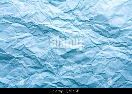 Blue wrinkled paper background with abstract seamless pattern. Crumpled paper texture. Stock Photo