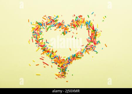 Simple concept flat lay with a heart made of sugar sprinkles. Stock Photo