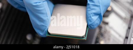 Handyman in rubber gloves installing computer processor closeup Stock Photo