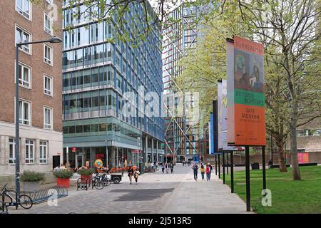 People walk on Sumner Street, the pedestrianised street south of the Tate Modern art museum, London, UK. Shows Neo Bankside apartments beyond. Stock Photo