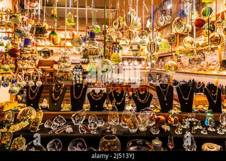 Hallstatt, Austria - November 1, 2019: Plenty of colorful gifts and decorating objects made from glass on shelf with bright light at souvenir retail s Stock Photo