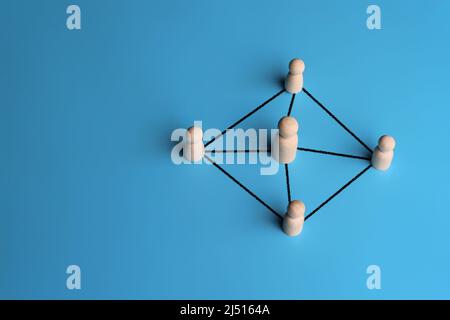 Wooden dolls connected by lines with copy space. Leadership, support, teamwork, networking concept Stock Photo