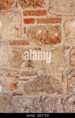 Old wall of large blocks and small bricks. Stock Photo