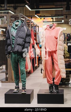 Mannequins in casual clothes stand in a clothing store. Mannequins in the big shopping shop. Stock Photo