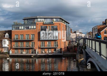 Eton, Windsor, Berkshire, UK. 19th April, 2022. A cyclist heads into Eton across Windsor Bridge. After a beautiful warm Easter Weekend, temperatures were cooler today at 13 degrees this morning. Credit: Maureen McLean/Alamy Live News Stock Photo